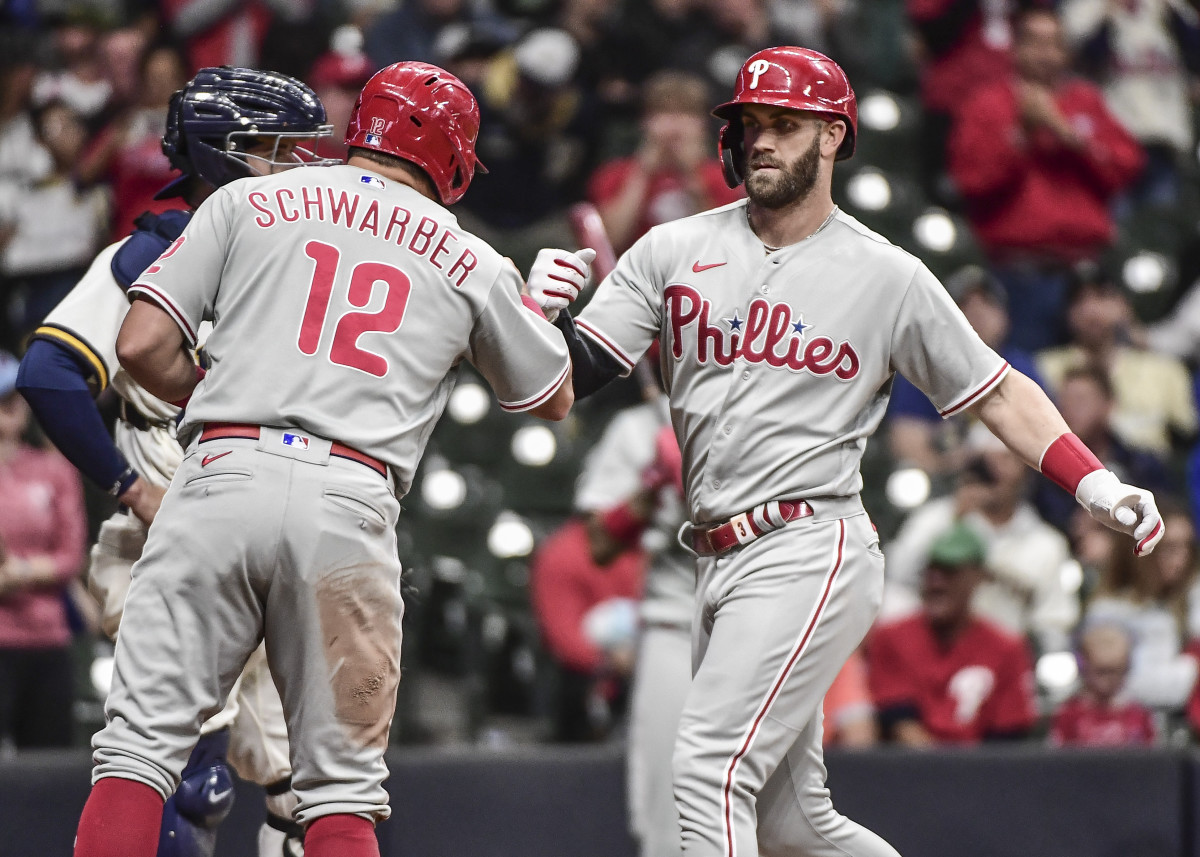 Kyle Schwarber celebrates Bryce Harper's three-run home run against the Milwaukee Brewers.